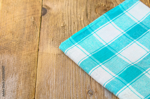 The blue-green towel lies on the old wooden table.