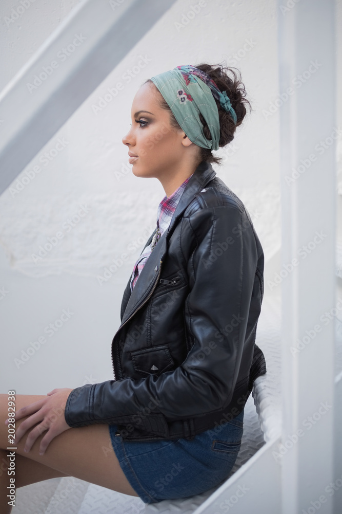 Serious woman with hairband sitting on stairs Serious woman with hairband sitting on stairs
