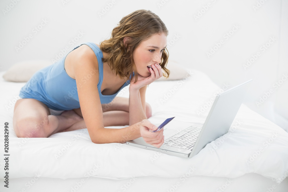 Concentrated pretty woman using her notebook for home shopping Concentrated pretty woman using her notebook for home shopping