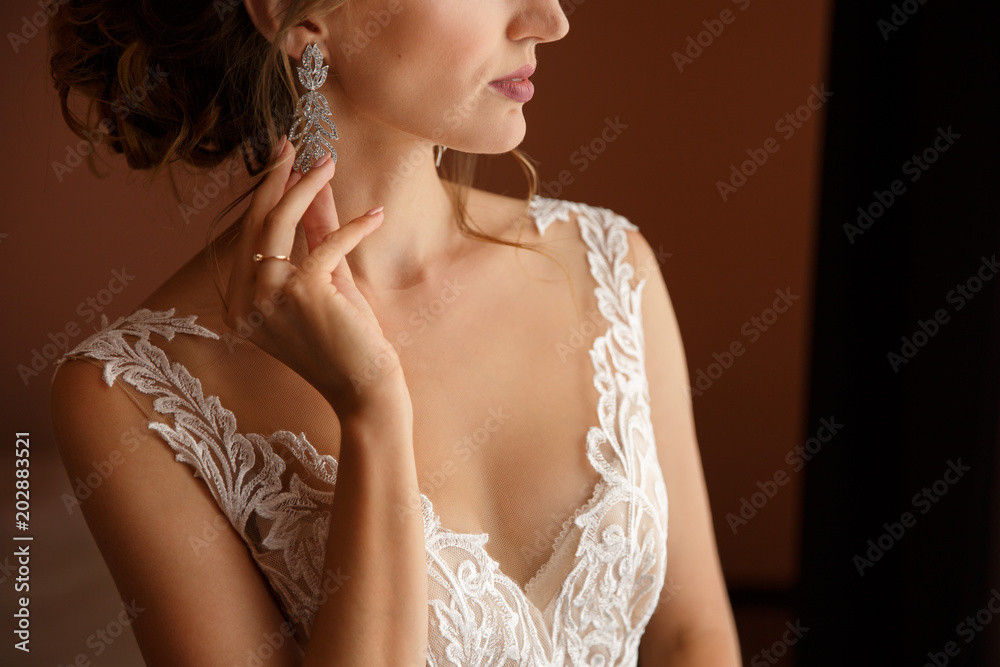 Fototapeta Biżuteria ślubna. Panna młoda trzyma kolczyki