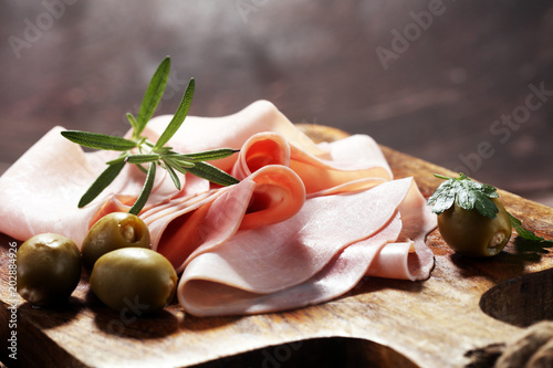 Fototapeta Naklejka Na Ścianę i Meble -  Sliced ham on wooden background. Fresh prosciutto. Pork ham sliced