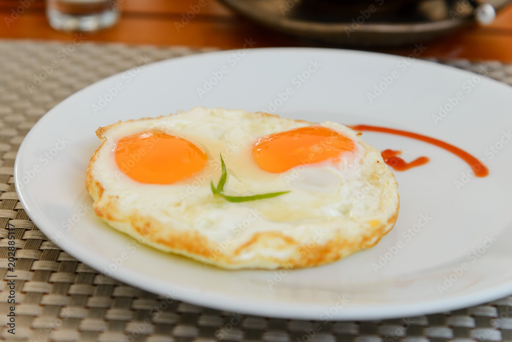 Traditional breakfast fried eggs on white dish Traditional breakfast fried eggs on white dish