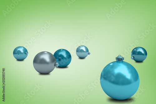 Digitally generated blue christmas baubles against green vignette