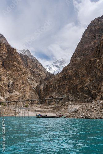Attabad lake and rocky mountain with local boat in Pakistan