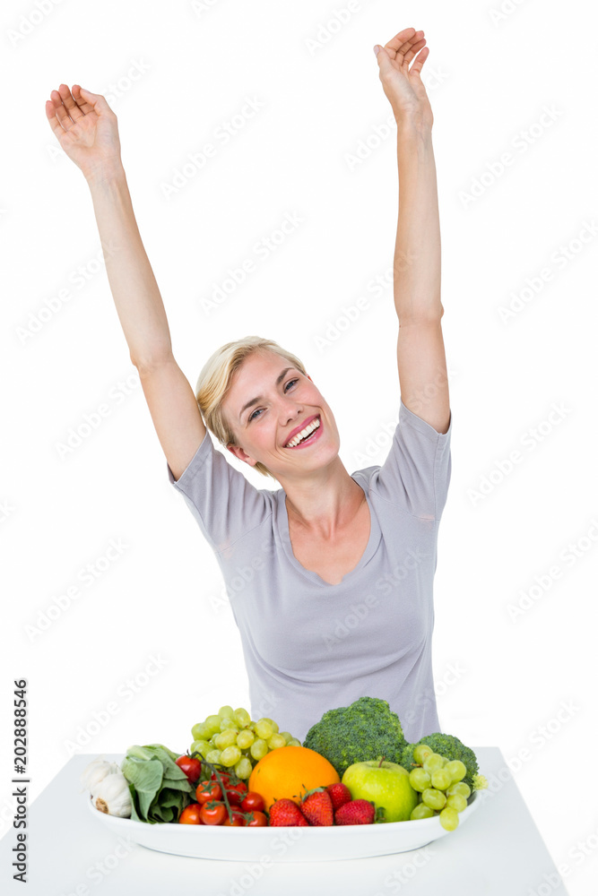 Happy blonde woman cheering while sitting above healthy food Happy blonde woman cheering while sitting above healthy food