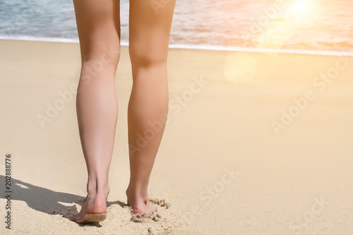 Beautiful female legs on summer beach
