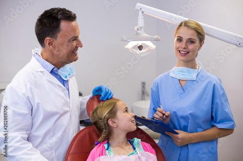 Dentist and young patient looking at nurse