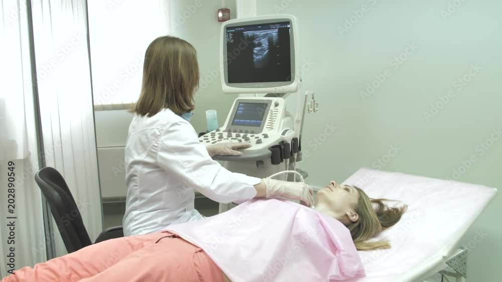 Female doctor examining the woman's neck using ultrasound scanner. Female doctor examining the woman's neck using ultrasound scanner.