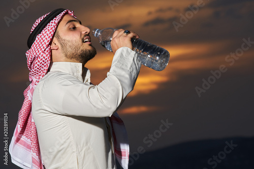 Muslim drinking water at sunset