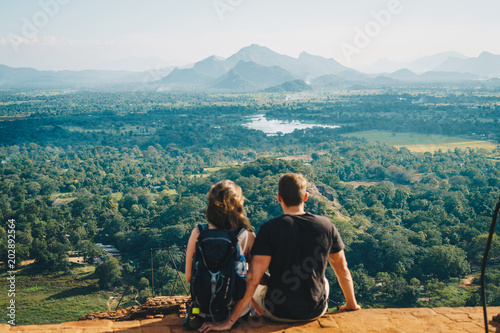 Pärchen sitzt auf einem Berg in Sri Lanka und schaut in die Ferne