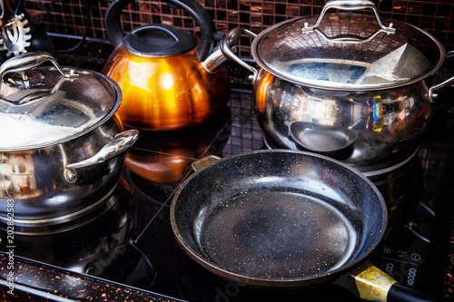 Shiny pans on the stove in the kitchen