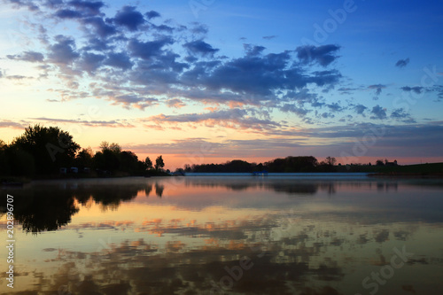 Fototapeta Naklejka Na Ścianę i Meble -  Morning over a lake in Poland, clouds are reflected in the surface of the water 