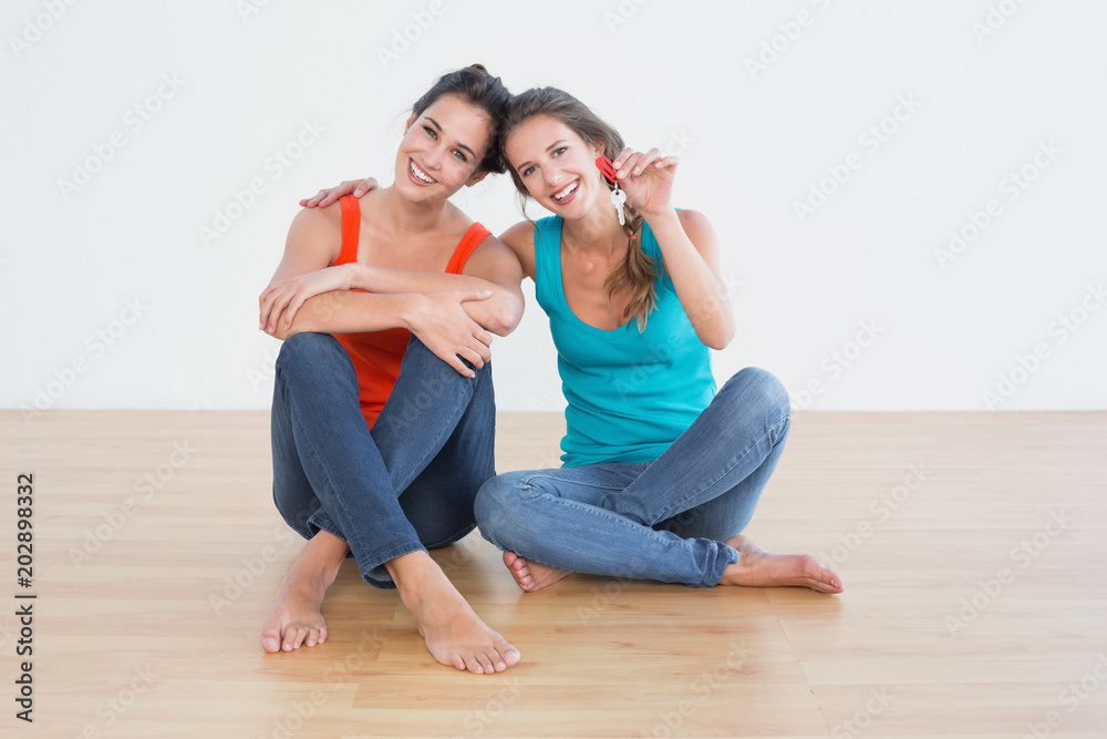 Friends with house keys sitting on the floor Friends with house keys sitting on the floor