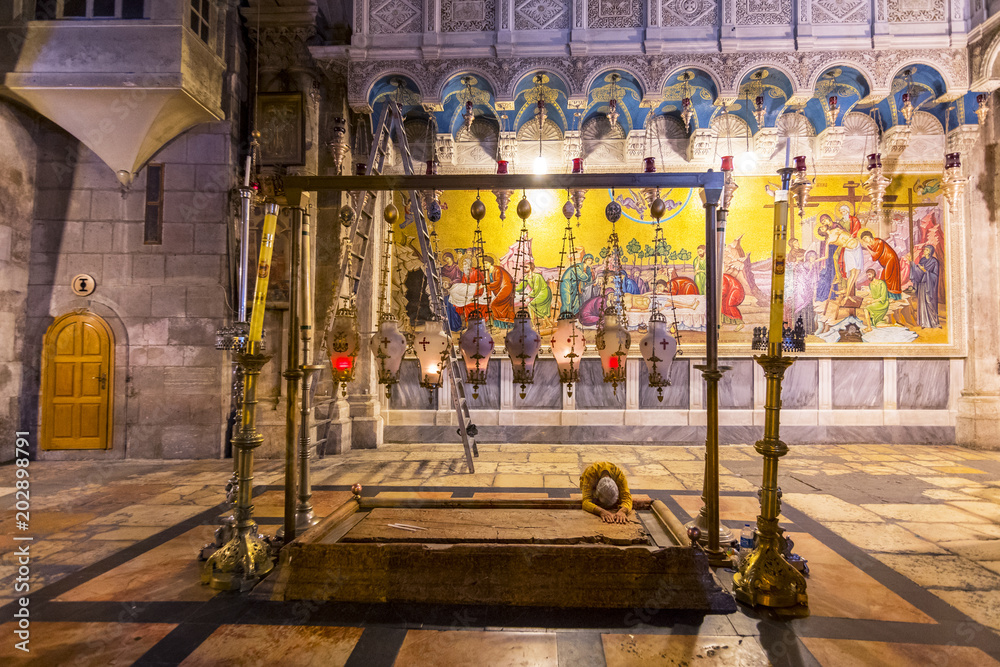 Ταπετσαρία Pilgrim prays at the Stone of Anointing or the Stone of Unction, Church of the Holy Sepulchre in Jerusalem, Israel, Middle East