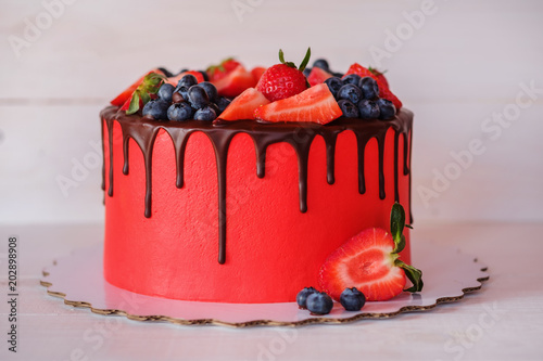 beautiful home made red cake with strawberries and blueberries