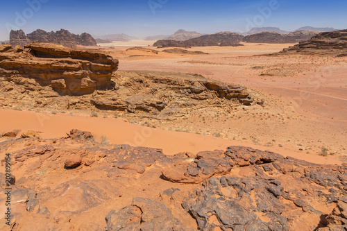 Reddish sand and rock landscapes in the desert of Wadi Rum, southern Jordan.