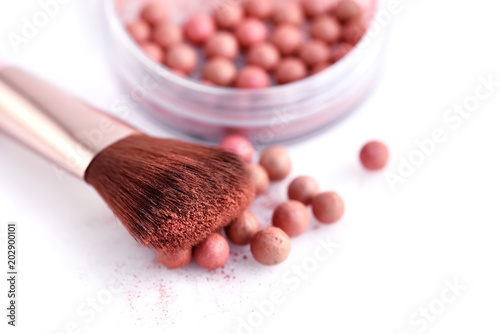 Cosmetic powder balls and makeup brush, isolated on white background. Shallow depth of focus