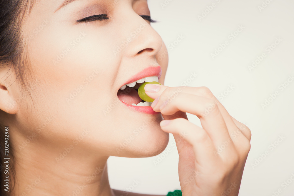 beautiful woman eating grapes is on the kitchen beautiful woman eating grapes is on the kitchen