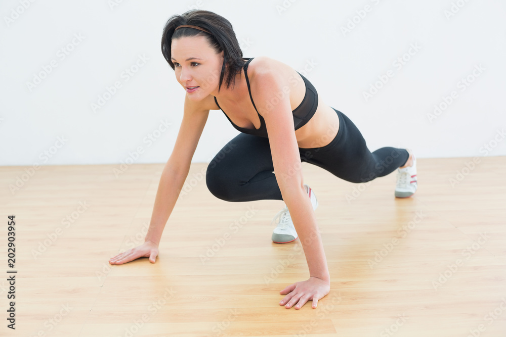 Determined woman doing push ups in fitness studio Determined woman doing push ups in fitness studio