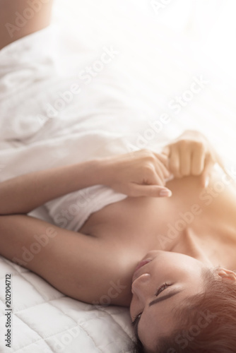 Young woman in bedroom sensuality concept lying thinking