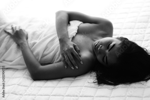 Young woman in bedroom sensuality black and white concept touching body