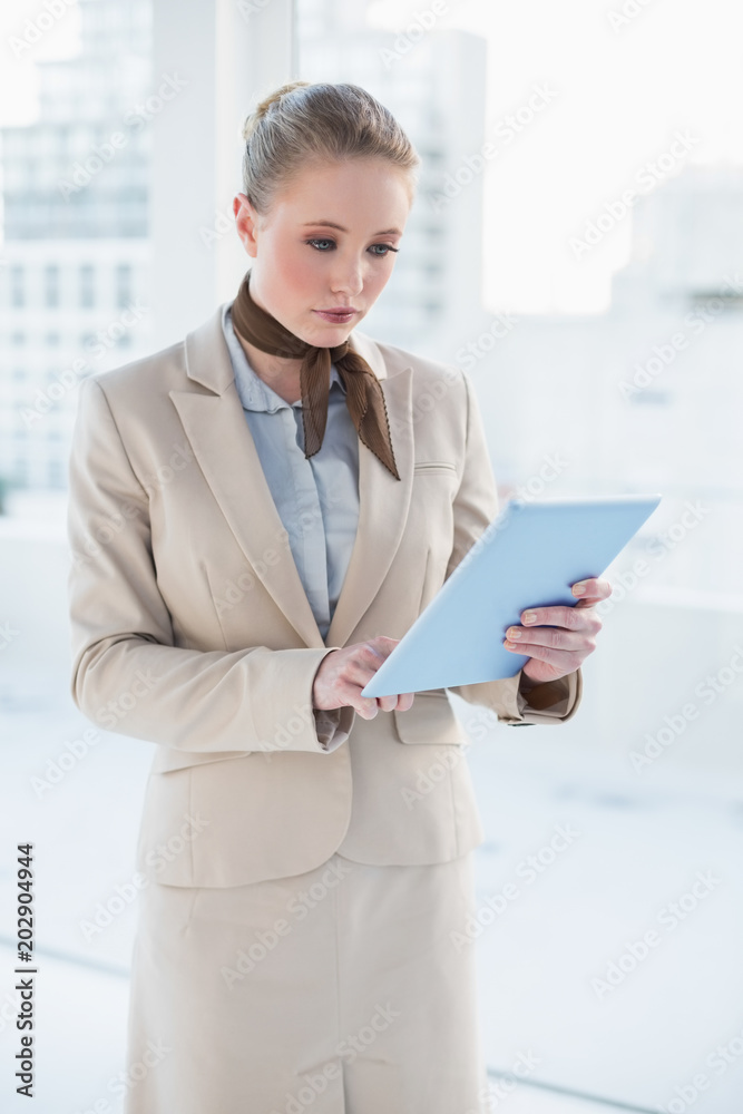 Blonde serious businesswoman looking at tablet Blonde serious businesswoman looking at tablet