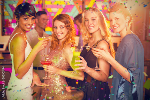 Group of friends having glass of cocktail in bar against flying colours
