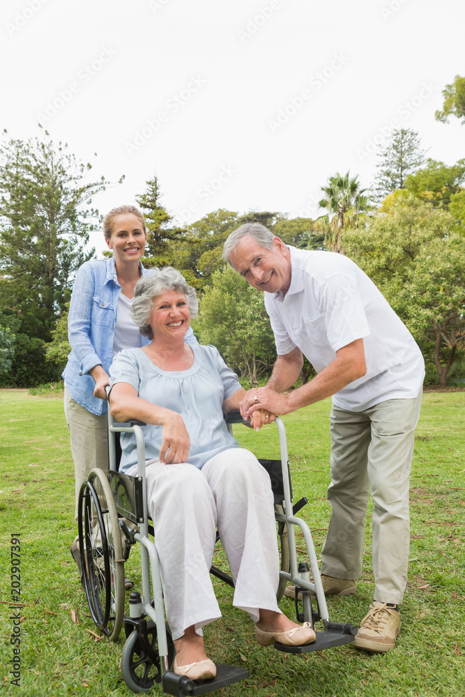 Woman sitting in wheelchair with husband and daughter Woman sitting in wheelchair with husband and daughter