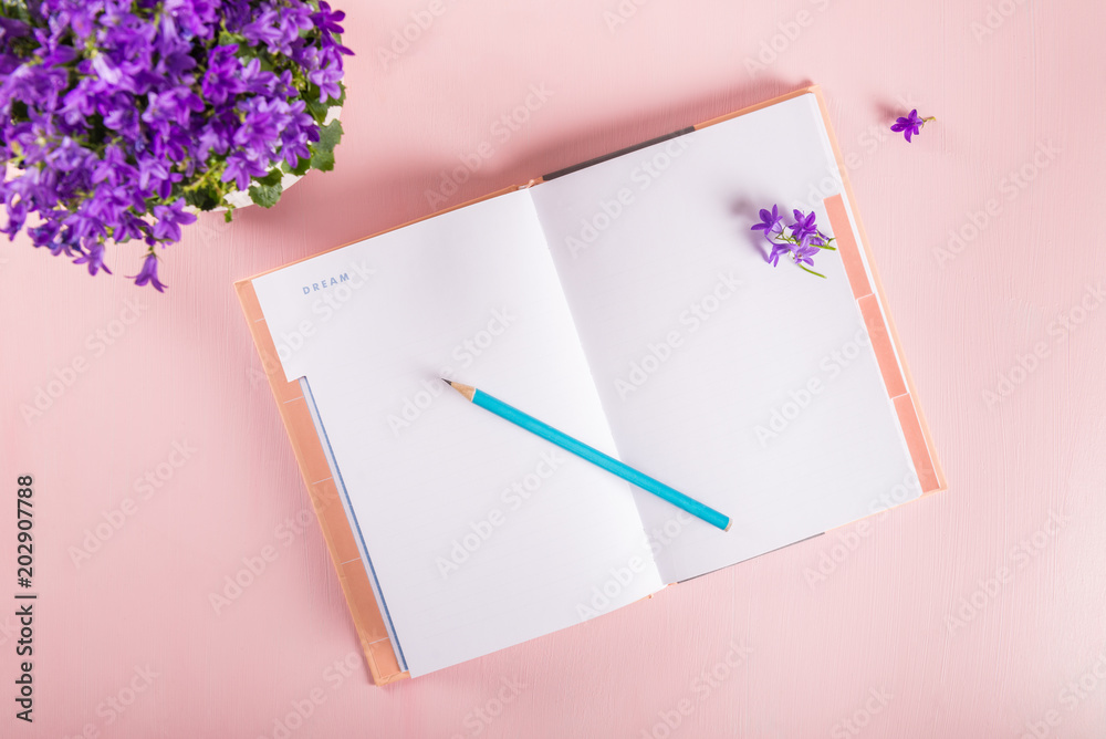 Open Notebook for writing Dreams and Ideas with flowers nearby Open Notebook for writing Dreams and Ideas with flowers nearby