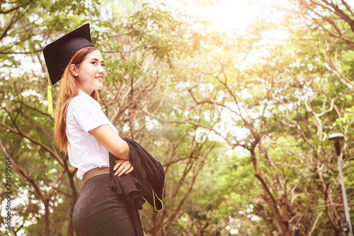 Asian female student graduate in public park.color tone