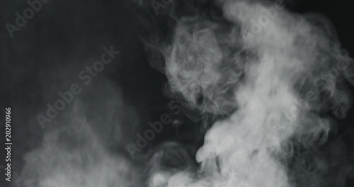 vapor steam rising over black background photo
