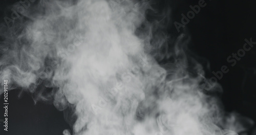 vapor steam rising over black background photo