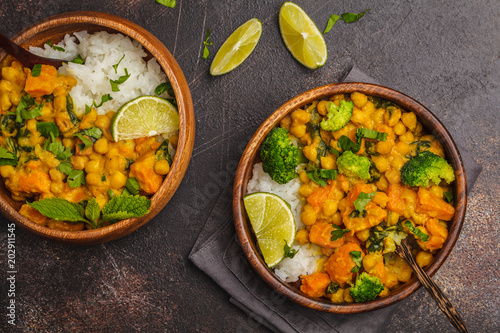 Vegan Sweet Potato Chickpea curry in wooden bowl on a dark background, top view. Healthy vegetarian food concept.