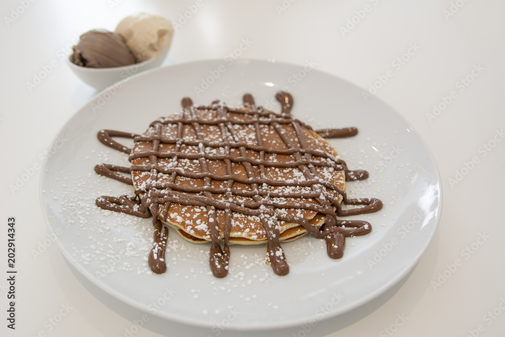 Fototapeta premium tortitas dulces con crema de chocolate y helado de dos sabores y azúcar glass