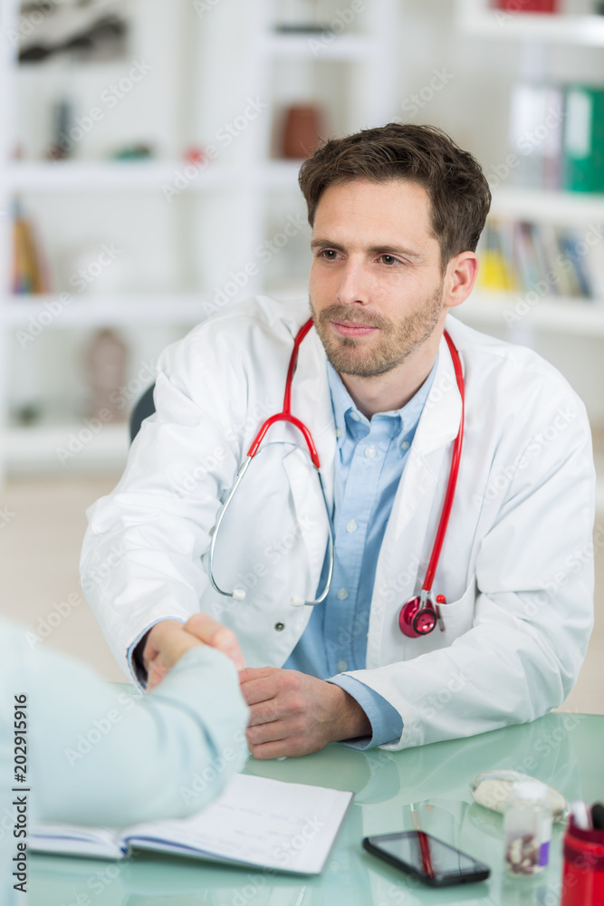 handsome young doctor at work in his office handsome young doctor at work in his office