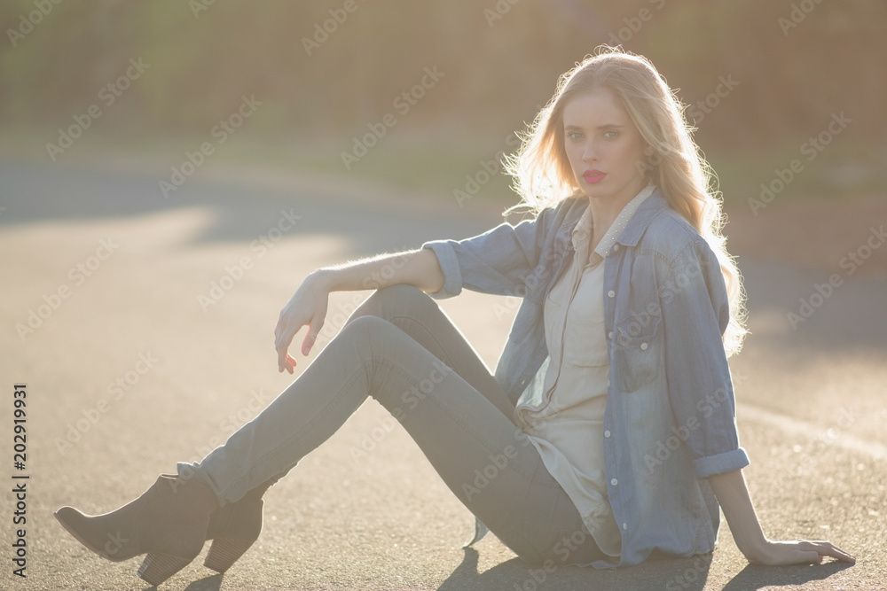Obraz premium Attractive woman sitting on road