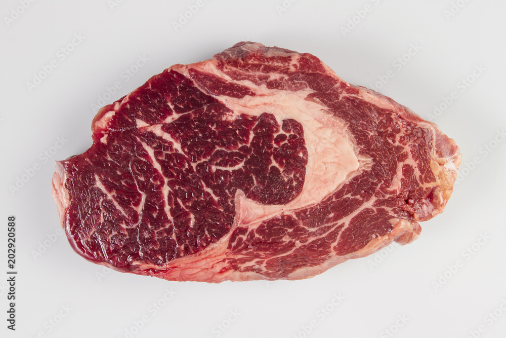 Ripened seasoned beef rib eye or entrecote steak on white background isolated.Top view.