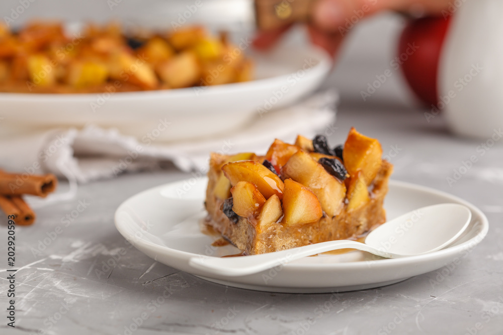 Piece of vegan apple pie with cinnamon, raisins and caramel, gray background.