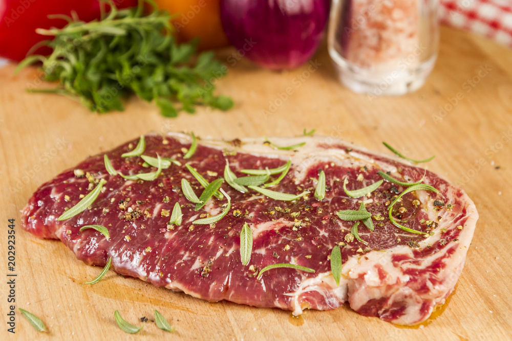 Ripened seasoned beef rump or striploin steak  on wooden cut board prepared for cooking