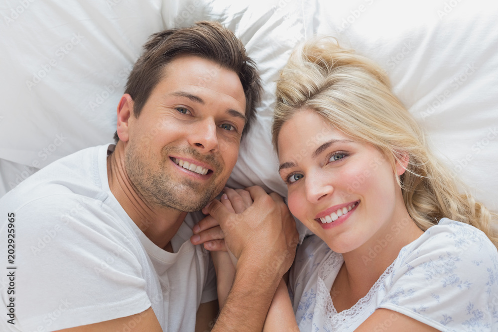 High angle portrait of a couple lying in bed High angle portrait of a couple lying in bed