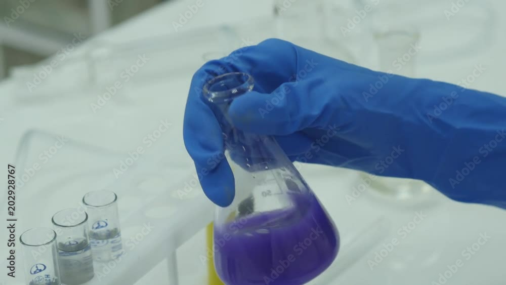 Female scientific researcher or doctor looking at a test tube