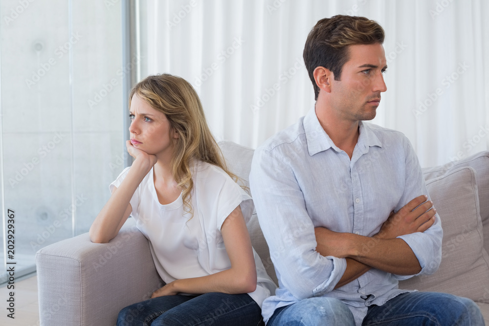 Couple not talking after an argument in living room Couple not talking after an argument in living room