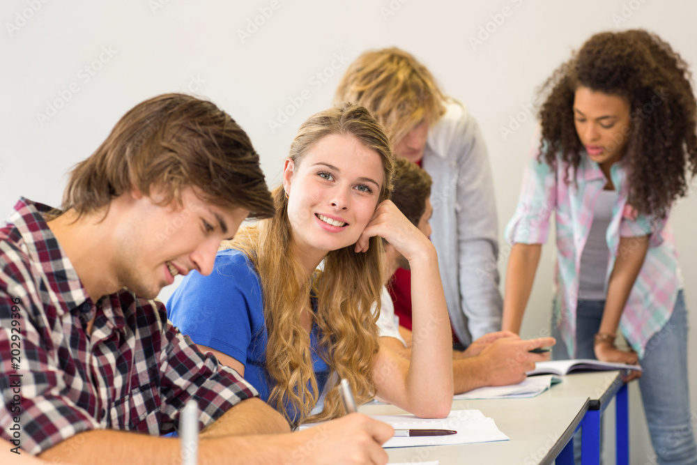Students writing notes in classroom Students writing notes in classroom