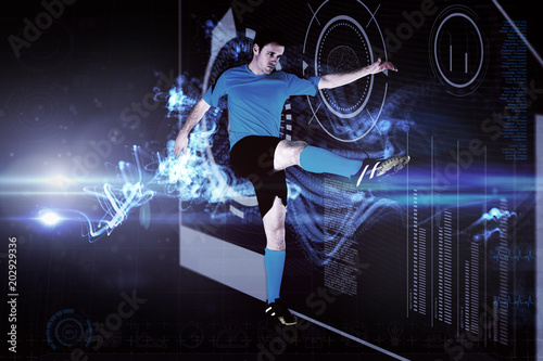 Football player in blue kicking against abstract glowing black background