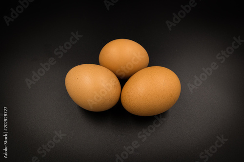 Three eggs brown orange on black backgound