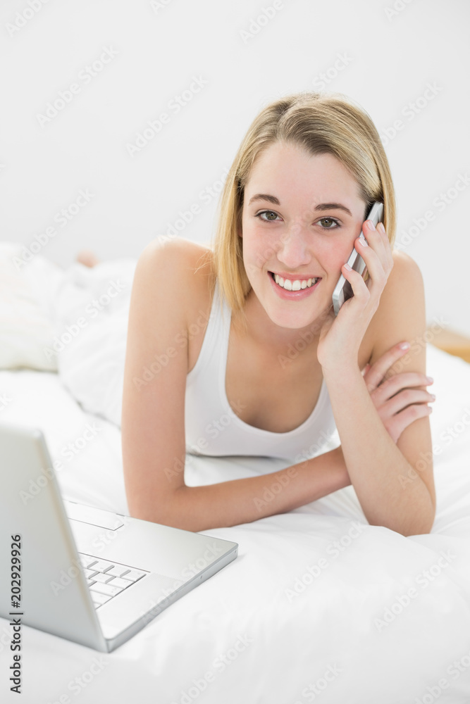 Beautiful blonde woman phoning peacefully lying on her bed Beautiful blonde woman phoning peacefully lying on her bed