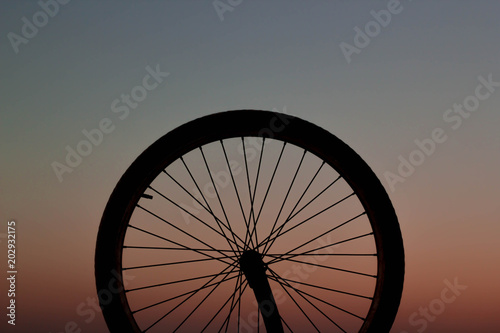 Bicycle wheel at the sunset. This photograph was taken in Matinhos, Paraná, Brazil. April 19, 2018
