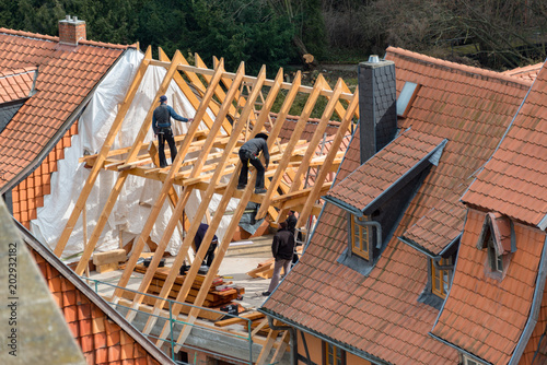 Zimmerleute und Dachdecker bei der renovierung eines Dachstuhls photo