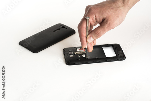 repair of phone with hands and screwdriver on white isolate background