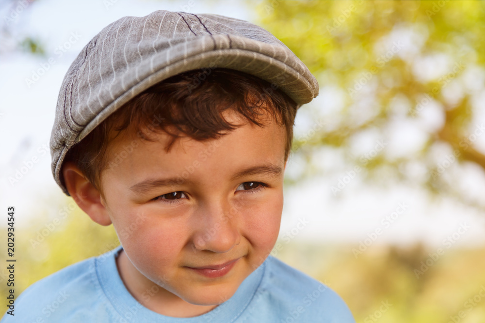 Kind kleiner Junge Textfreiraum Copyspace schaut zur Seite Portrait mit Mütze draußen